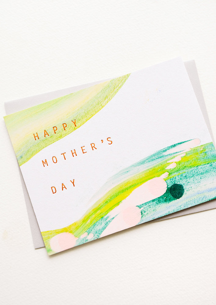 Greeting card with hand-painted streaks of color and copper text reading "Happy Mother's Day"