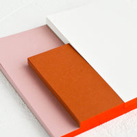 5: A sectioned notepad with red binding.