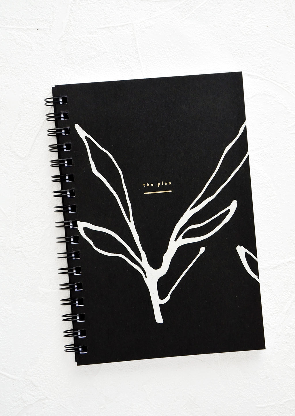 Seaweed Stroke: Spiral bound planner with black cover and hand-painted, abstract seaweed outline in white