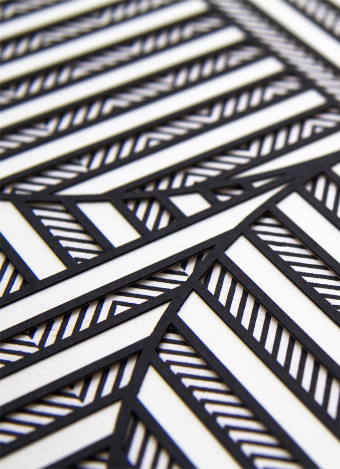 2: A close up of textured layers of paper in black and white creating a geometric pattern.