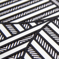 2: A close up of textured layers of paper in black and white creating a geometric pattern.