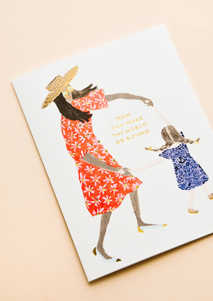 2: Greeting card picturing illustration of mother and child, text reading "Mom, You Make The World Go Round"