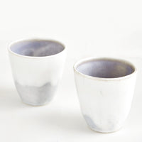 1: Two small ceramic cups in drippy ivory and grey-blue glaze.
