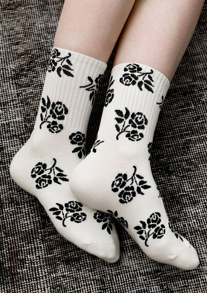 2: A pair of ivory socks with black floral print.