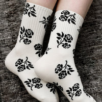 2: A pair of ivory socks with black floral print.