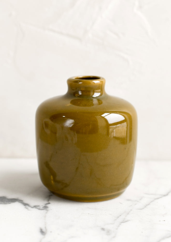 A ceramic bud vase in short shape, olive color.