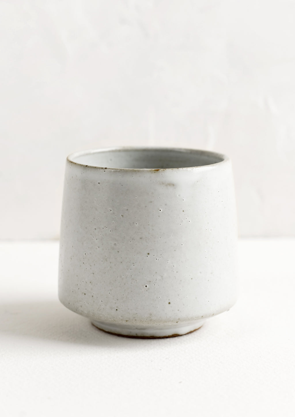 Snow: A small footed ceramic cup in satin natural white glaze.