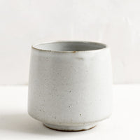 Snow: A small footed ceramic cup in satin natural white glaze.