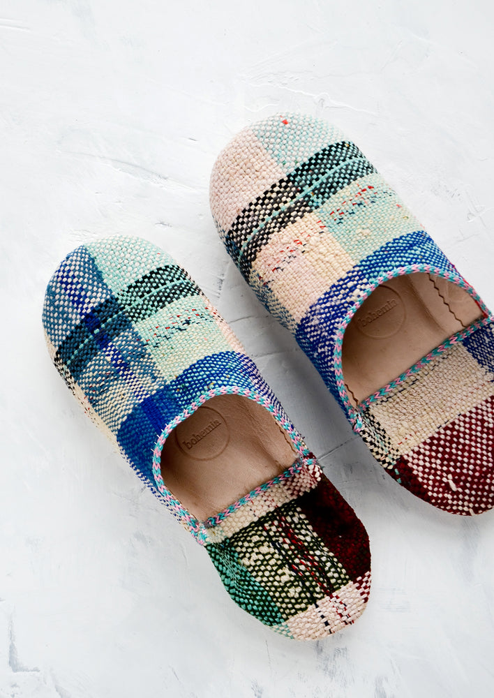 A single pair of house slippers made from colorful plaid melange fabric.