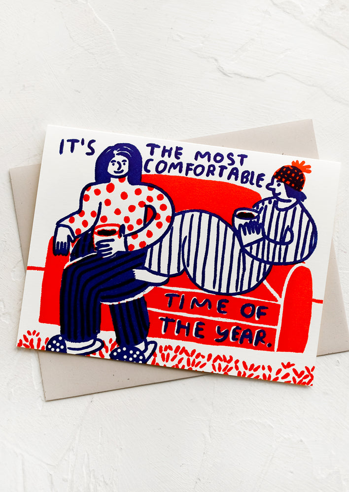 A greeting card with drawing of two people on a couch, text reads "It's the most comfortable time of the year".