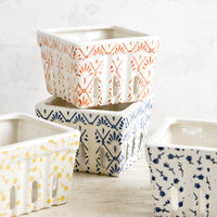 1: White ceramic berry baskets in primary colors and assorted patterns.