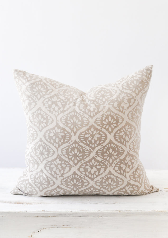 A light grey and white floral block printed square pillow.