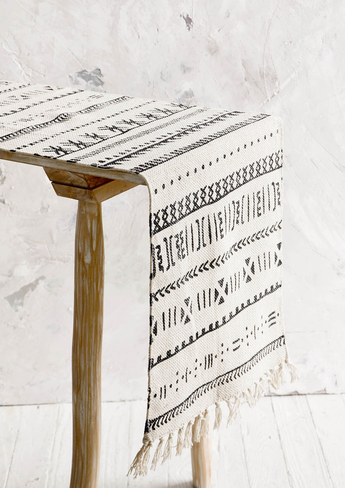 Table runner displayed on a console table, thick canvas material with black geometric print