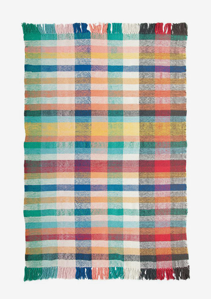 A rug with allover multicolor madras plaid pattern.