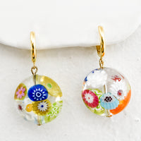 Multicolor: A pair of gold huggie hoops with multicolor murano glass beads.