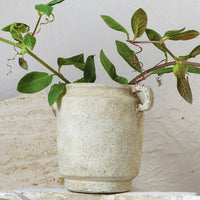 4: A distressed beige ceramic vase with handles at top sides.