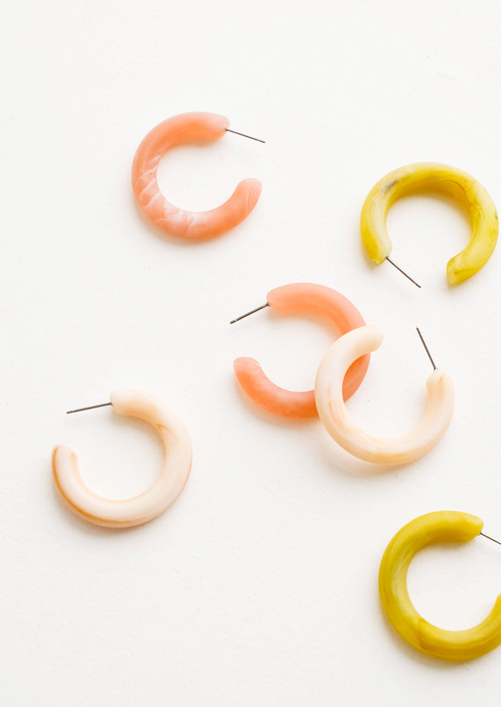 Scattered array of different colored hoop earrings in matte resin