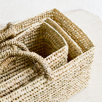 3: Palm leaf baskets in narrow, rectangular shape, nested together.