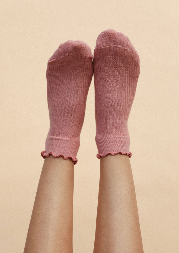 Rose: Legs wearing a pair of pink ankle socks.