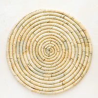 1: A round placemat made from natural dried straw.