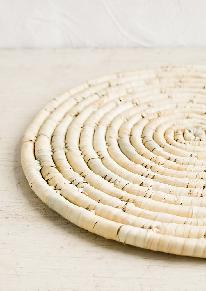 3: A round placemat made from natural dried straw.