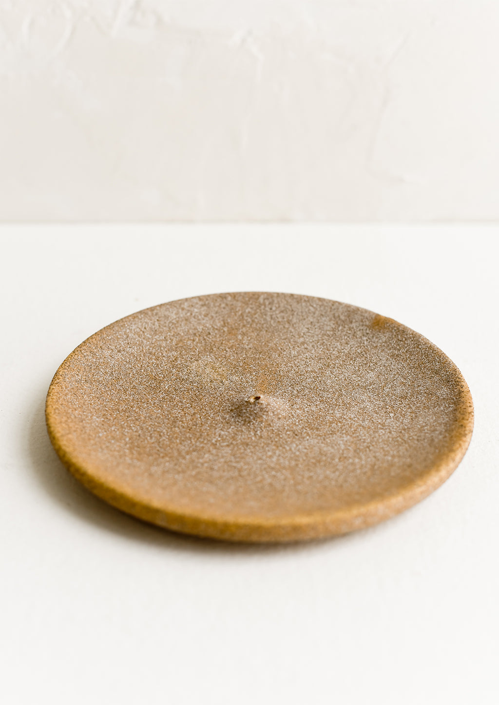 Sandy Brown: A round ceramic incense holder in matte sandy brown.