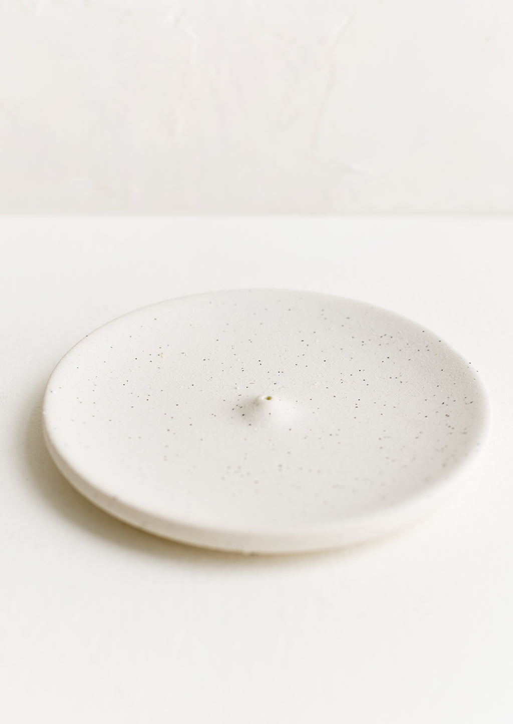 Speckled White: A round ceramic incense holder in matte speckled white.