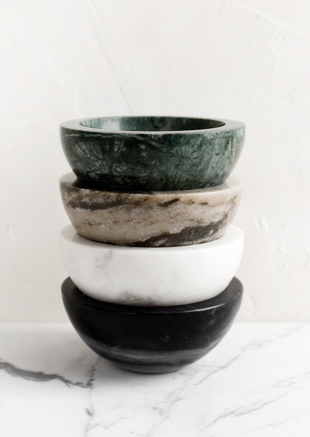 1: A stack of four small marble bowls in assorted colors.