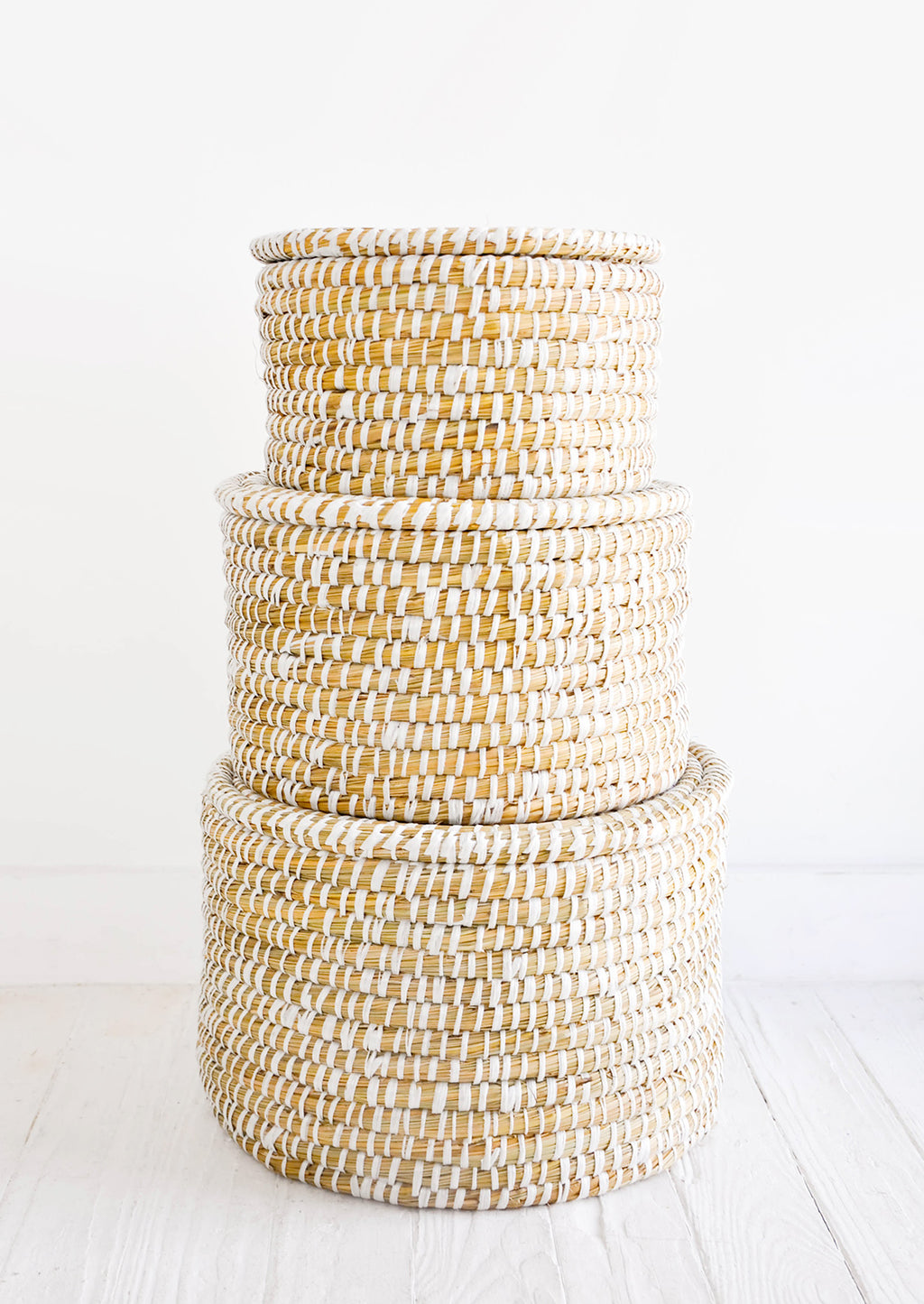2: Stack of round, lidded storage baskets in three incremental sizes