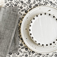 2: A neutral table setting with plates, napkins and placemat.