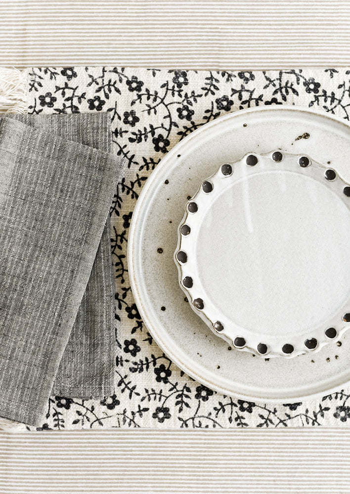 2: A neutral table setting with plates, napkins and placemat.