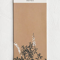 1: A brown plain notebad with floral print at the bottom edge.