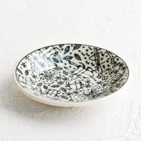 2: A round ceramic trinket dish in black and white with insect print.