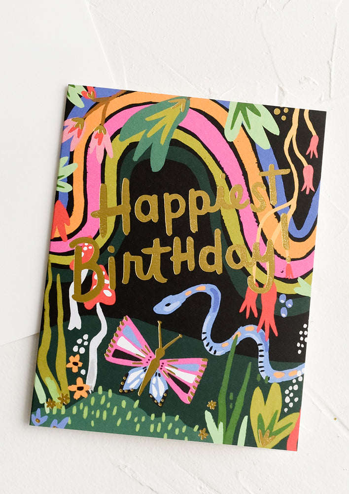 A birthday card with illustration of jungle creatures at night and text reading "Happiest birthday!".