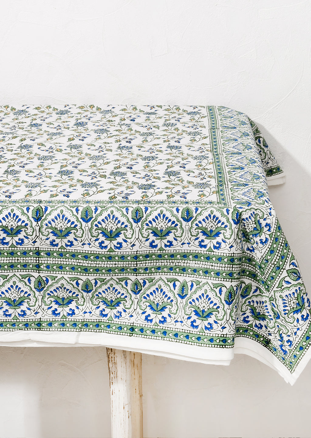 2: A block printed tablecloth in blue and green floral.