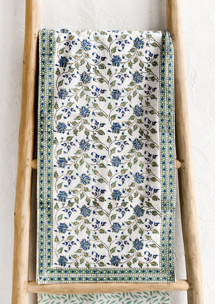 A table runner with blue and green floral block print.