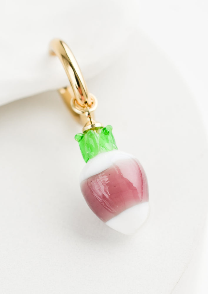 Turnip: A single earring with glass turnip charm on gold huggie hoop.