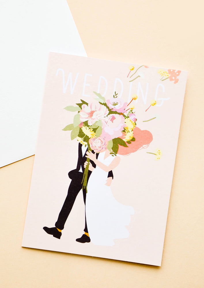 1: Pink greeting card with illustration of a bride and groom holding oversized floral bouquet. "Wedding" written in white text.