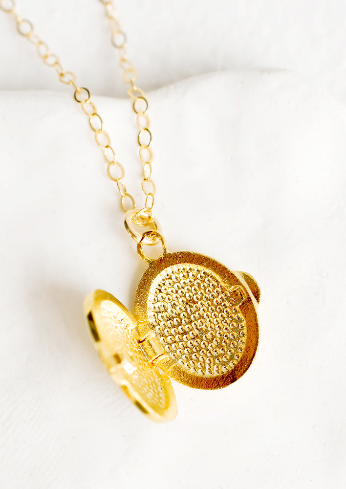 The inside of a gold locket necklace.