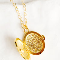 2: The inside of a gold locket necklace.
