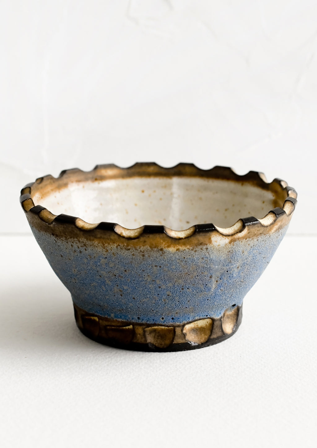 Cornflower / Toast: A ceramic bowl with carved notch rim in blue and brown.
