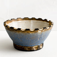 Cornflower / Toast: A ceramic bowl with carved notch rim in blue and brown.