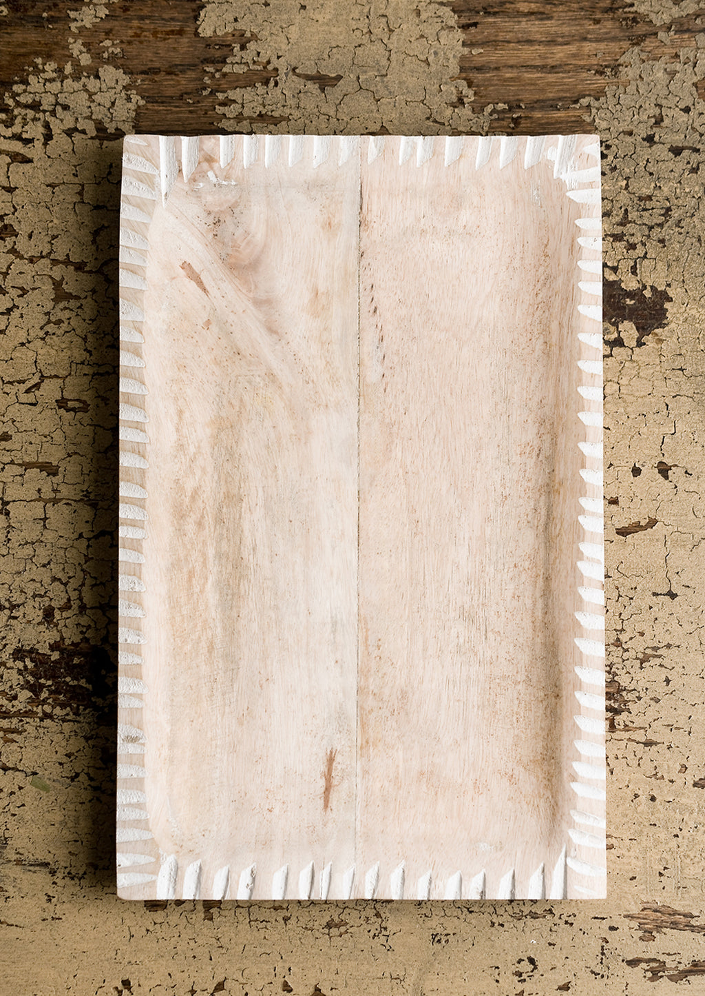 Wide: A rectangular tray in light colored wood with white painted notched border.