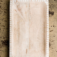 Wide: A rectangular tray in light colored wood with white painted notched border.
