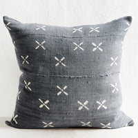 1: A dusty blue mudcloth pillow with white X pattern.