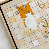 2: A framed original painting of checkered still life panel in beige, white and rust.