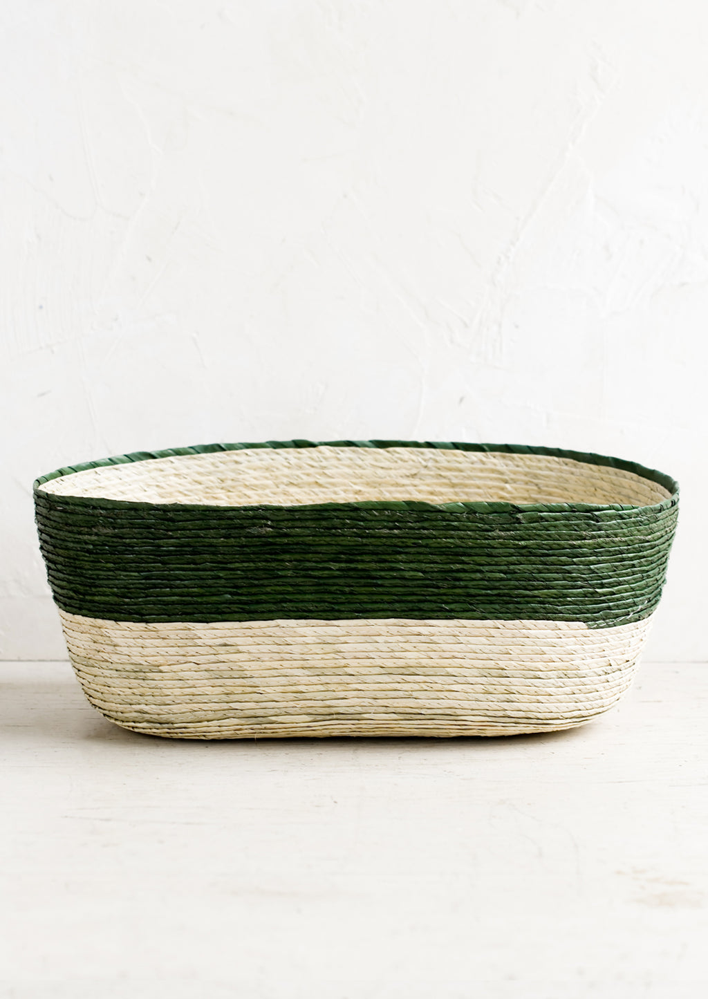 Pine: A two-tone oval shaped storage basket in natural and pine green.