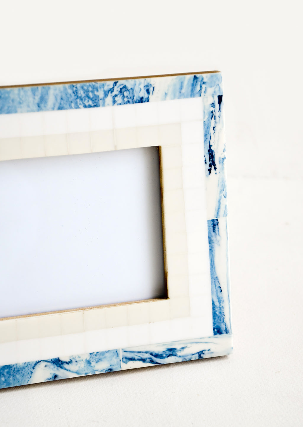 2: A tiled border in blue, white and cream around a decorative photo frame.