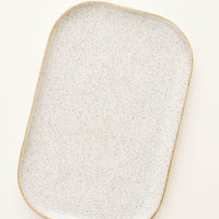 3: Glossy white ceramic tray with brown speckles.