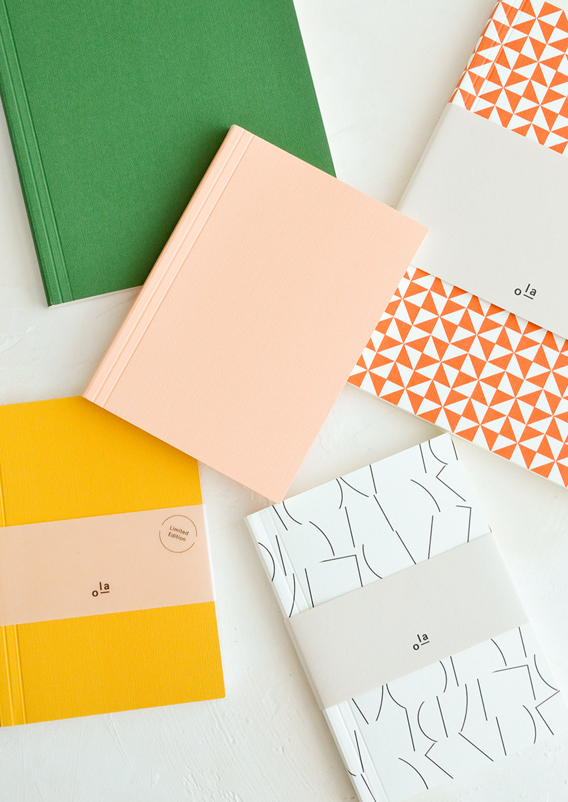 A group of colorful writing notebooks in assorted sizes and colors.